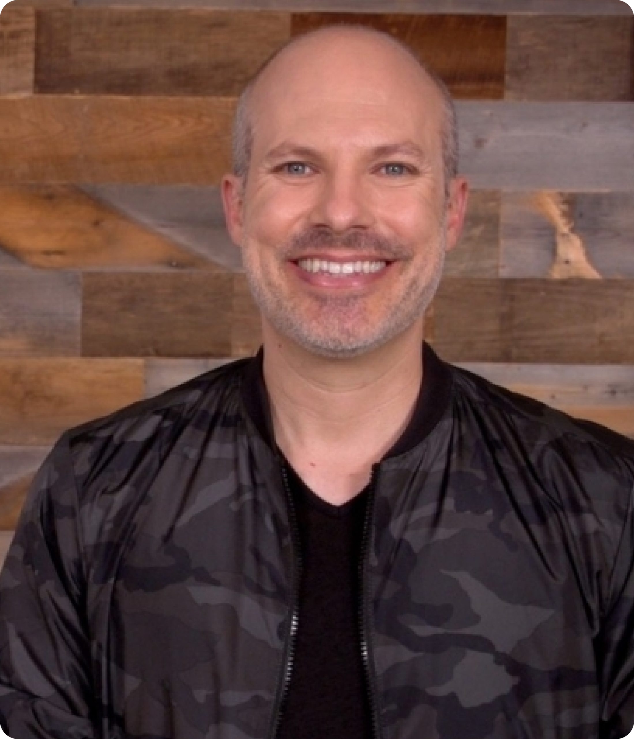 Steve is wearing a black camouflage jacket on top of a black shirt.