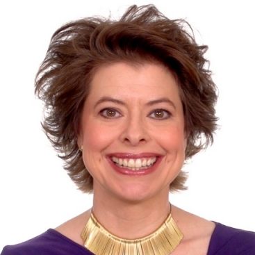 A woman from the Rising Effect is wearing a violet top and a big golden necklace.