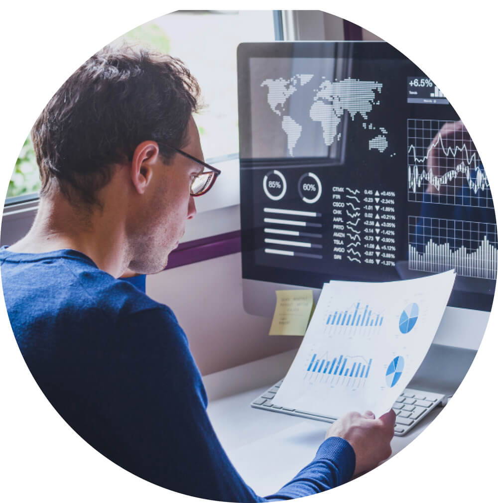 man on computer looking at spreadsheets