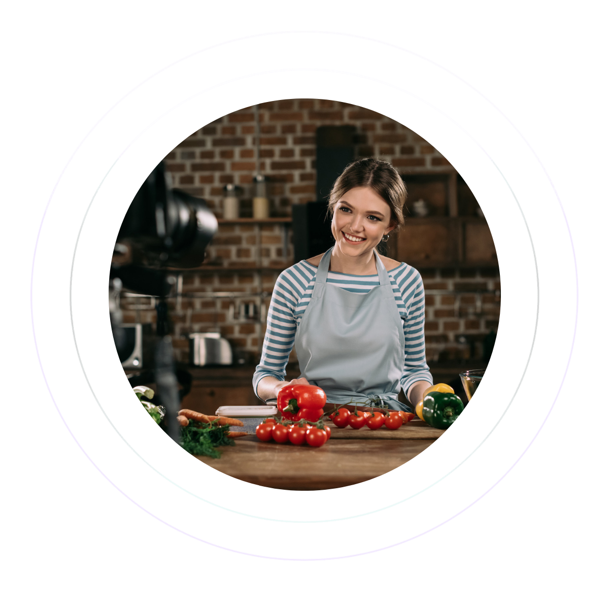 A woman is being filmed behind her kitchen counter with peppers and tomatoes in front of her.