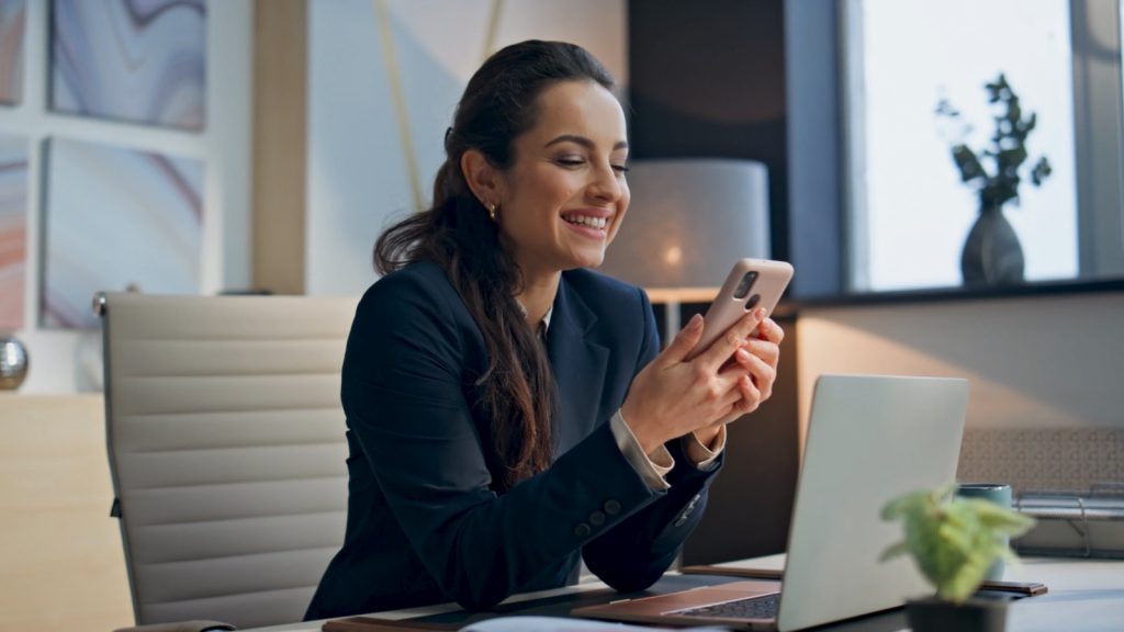 A female business owner is happy about the success of her digital paid ads campaign.