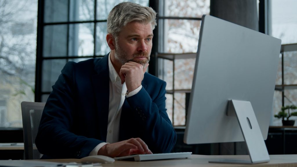 A businessman searches online for resources for his business.